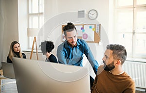 Group of young businesspeople with laptop working in a modern office.