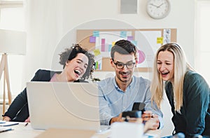 Group of young businesspeople with laptop working together in a modern office.