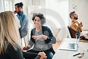 Group of young businesspeople with laptop working together in a modern office.