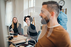 Group of young businesspeople with laptop working together in a modern office.