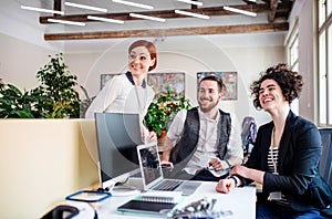 Group of young businesspeople using laptop in office, start-up concept.