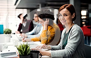 A group of young businesspeople with VR goggles working in office.