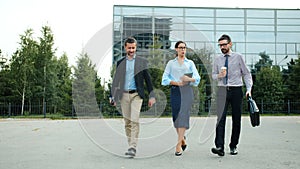 Group of young businesspeople walking together outdoors having conversation