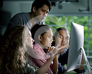 Group of young businesspersons looking intently at the screen