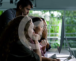 Group of young businesspersons looking intently at the screen