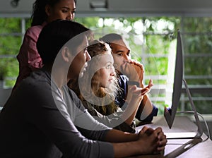 Group of young businesspersons looking intently at the screen