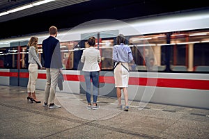 Group of young caucasian business people at subway station waiting for a train