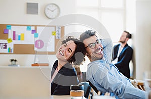 Group of young cheerful businesspeople working together in a modern office.