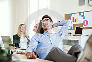 Group of young cheerful businesspeople working together in a modern office.