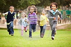 Group Of Young Children Running Towards Camera In Park