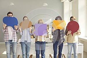 Group of young college students holding multicolored empty mockup speech bubbles