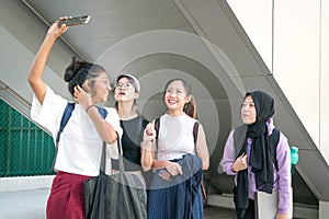 Group of young college women students laughing and taking selfie