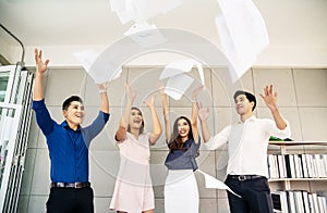Group of young confident business people  happy smile celebrating  by throwing their business papers in the air, success team