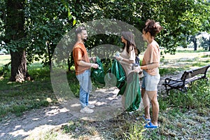 Group of young conscious activists collect and clean up trash from the park to keep the environment clean. Friends reduce