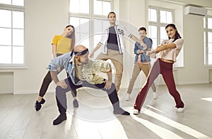 Group of young contemporary or hip hop dancers dancing together in a modern studio