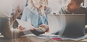 Group of young coworkers working together in modern coworking studio.Woman using smartphone for talking with partners