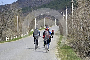 Group of young cyclists are driving along an asphalt road
