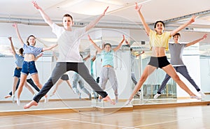 Group of young dancers jumping together in class