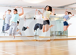 Group of young dancers jumping together in class