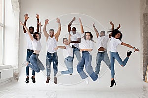 Group of young diverse People dancers jumping on white background in studio. Guys and girls in white t-shirts and jeans