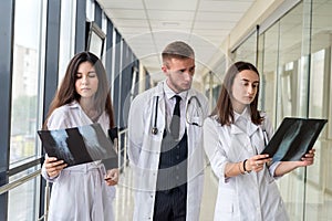Group of young doctors discuss and looking x-ray scan leg in a clinic