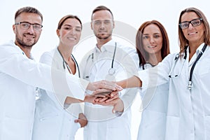 Group of young doctors putting their palms together.