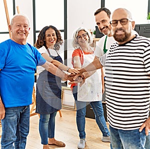 Group of young draw students smiling happy standing with hands together at art studio