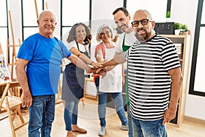 Group of young draw students smiling happy standing with hands together at art studio