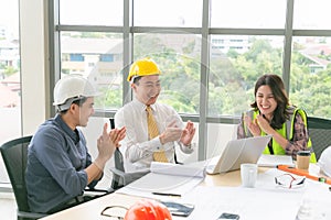 Group of young engineers team giving high five and celebrating success at office. Cheerful startup business team