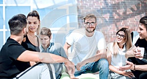 Group of young entrepreneurs sit on the floor in the new office photo