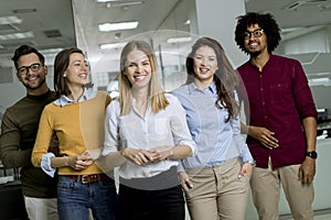 Group of young excited business people standing in office