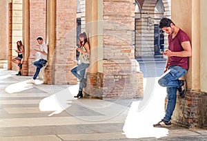 Group of young fashion friends using smartphone in urban area