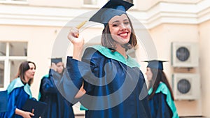 A group of young female graduates. Female graduate is smiling against the background of university graduates