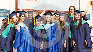 A group of young female graduates. Female graduate is smiling against the background of university graduates