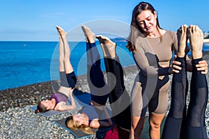 Group of young females practicing yoga on the seaside