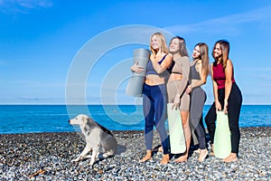 group of young females practicing yoga on the seaside