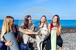 group of young females practicing yoga on the seaside