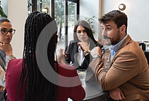 Group of young freelancers real estate agents have business meeting in cafeteria discussing about prices and situation on the rent