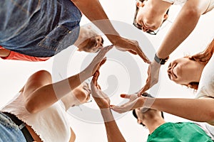 Group of young friends doing circle symbol with hands together