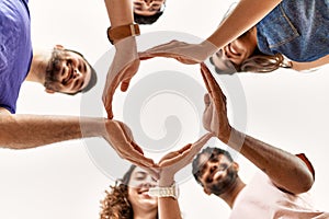 Group of young friends doing circle symbol with hands together