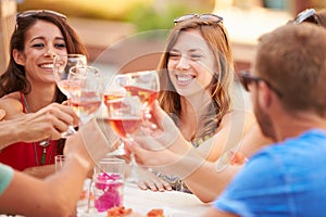 Group Of Young Friends Enjoying Meal In Outdoor Restaurant