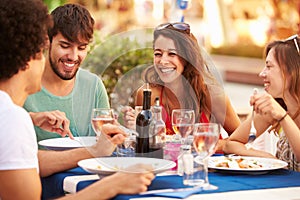 Group Of Young Friends Enjoying Meal In Outdoor Restaurant photo