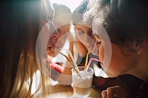 Group of young friends hanging out at a coffee shop. Young men and women meeting in a cafe having fun and drinking coffee. Lifesty