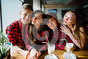 Group of young friends hanging out at a coffee shop. Young men and women meeting in a cafe having fun and drinking coffee. Lifesty