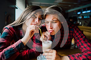 Group of young friends hanging out at a coffee shop. Young men and women meeting in a cafe having fun and drinking coffee. Lifesty