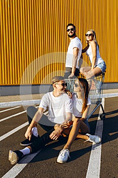 A group of young friends are having fun in the city with a shopping cart. The concept of shopping