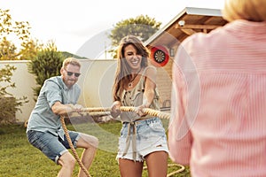 Friends participating in rope pulling competition