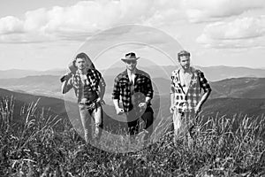 Group of young friends hiking in countryside. Three men walking by hiking trail. Three Friends Travel and Adventure