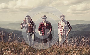 Group of young friends hiking in countryside. Three men walking by hiking trail. Three Friends Travel and Adventure