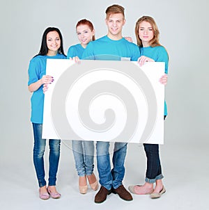 Group of young friends holding a blank board, isolated on white background